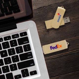 Two beige eco swivel drives printed with a logo on a wooden desk next to a laptop keyboard