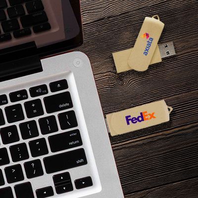 Two beige eco swivel drives printed with a logo on a wooden desk next to a laptop keyboard