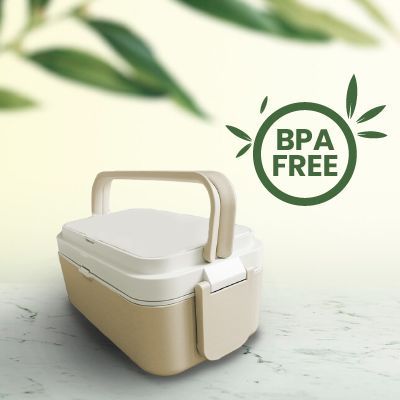 Two-tier bamboo fibre lunch box with a carry handle on a marble surface, with a BPA free badge and green leaves