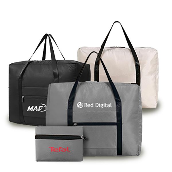 Grey, cream and navy folded duffels with black handles, with a grey pouch and a small printed pouch in front.