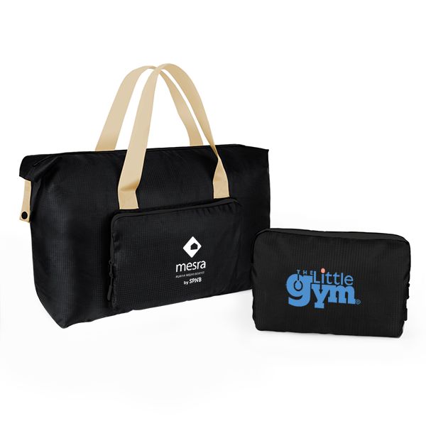 Black foldable duffel with cream webbing handles beside its navy folded pouch, both printed with a logo.