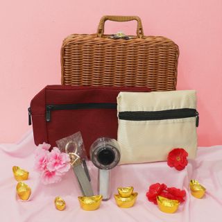 Rattan case hamper with a maroon zip pouch, a cream zip pouch, a stainless straw set and a key ring, on gold ingots and blossoms.