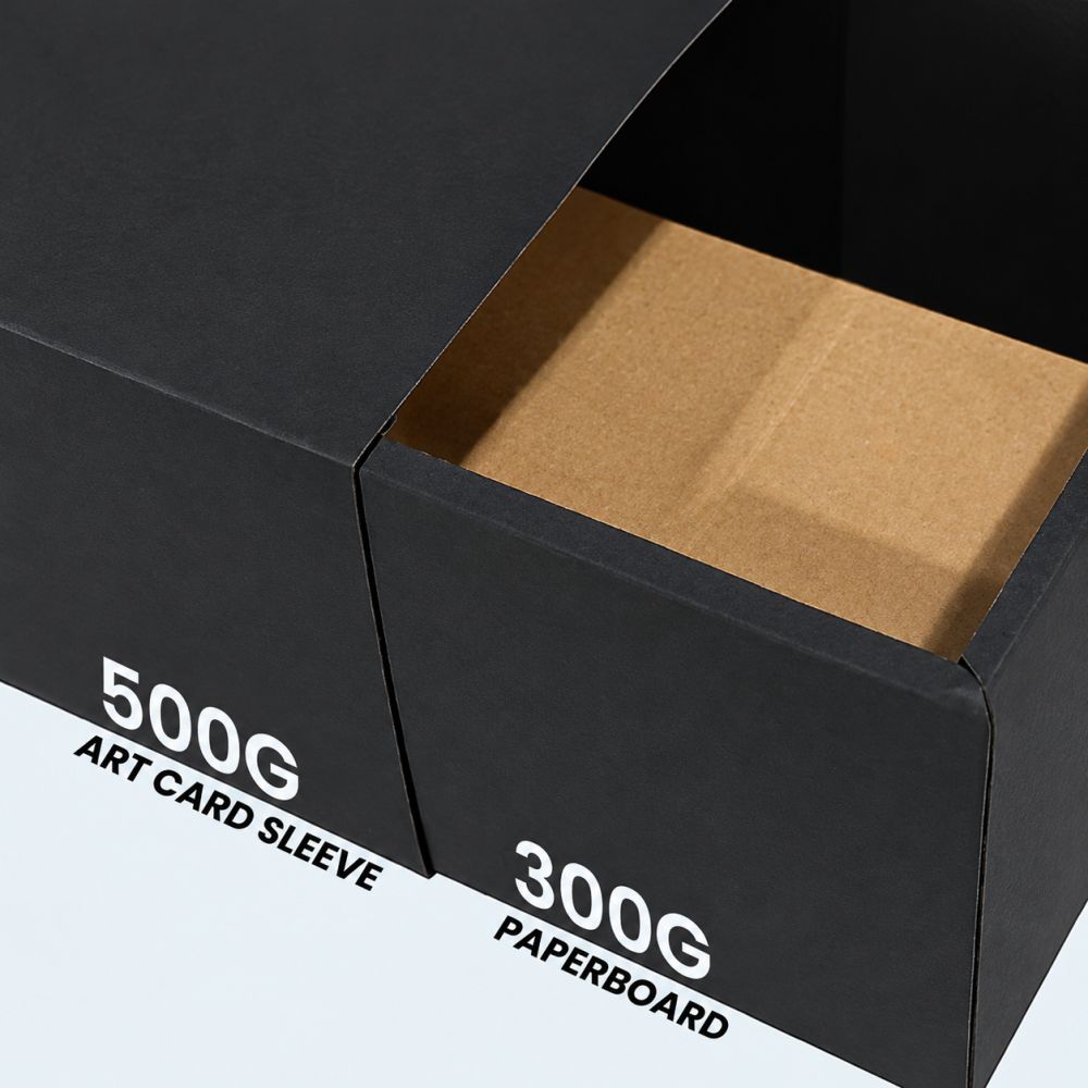 Close-up of a black slide gift box showing the art card outer sleeve over a kraft paperboard inner tray
