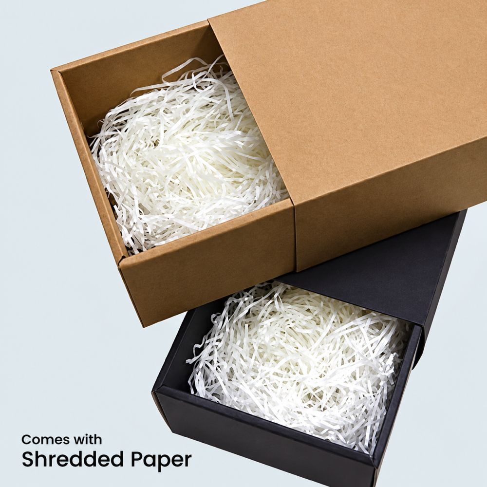 Brown and black slide gift boxes with their trays pulled half out, each filled with white shredded paper