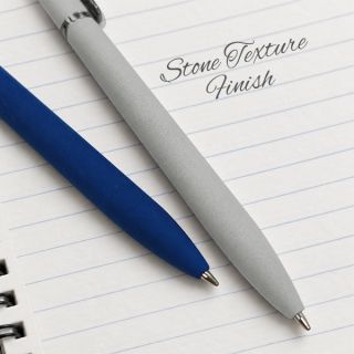 Navy blue and light grey stone-texture aluminium pens lying on a lined notebook page