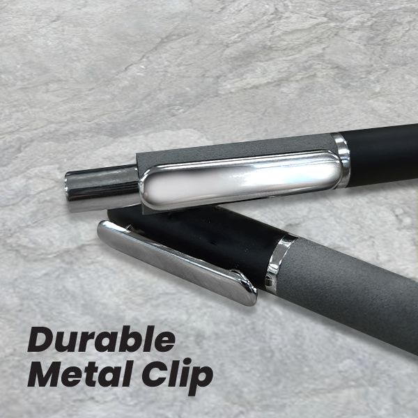 Close-up of the silver metal clips on two duo tone stone-texture pens lying on a marble surface