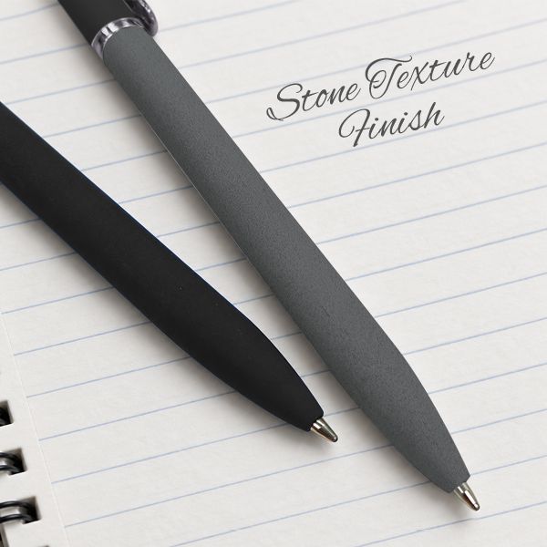Black and grey stone-texture pens lying on a lined notebook page