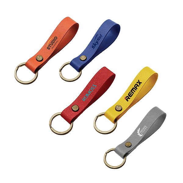 Five PU leather key fobs in orange, blue, red, yellow and grey with riveted metal rings, each printed with a logo.